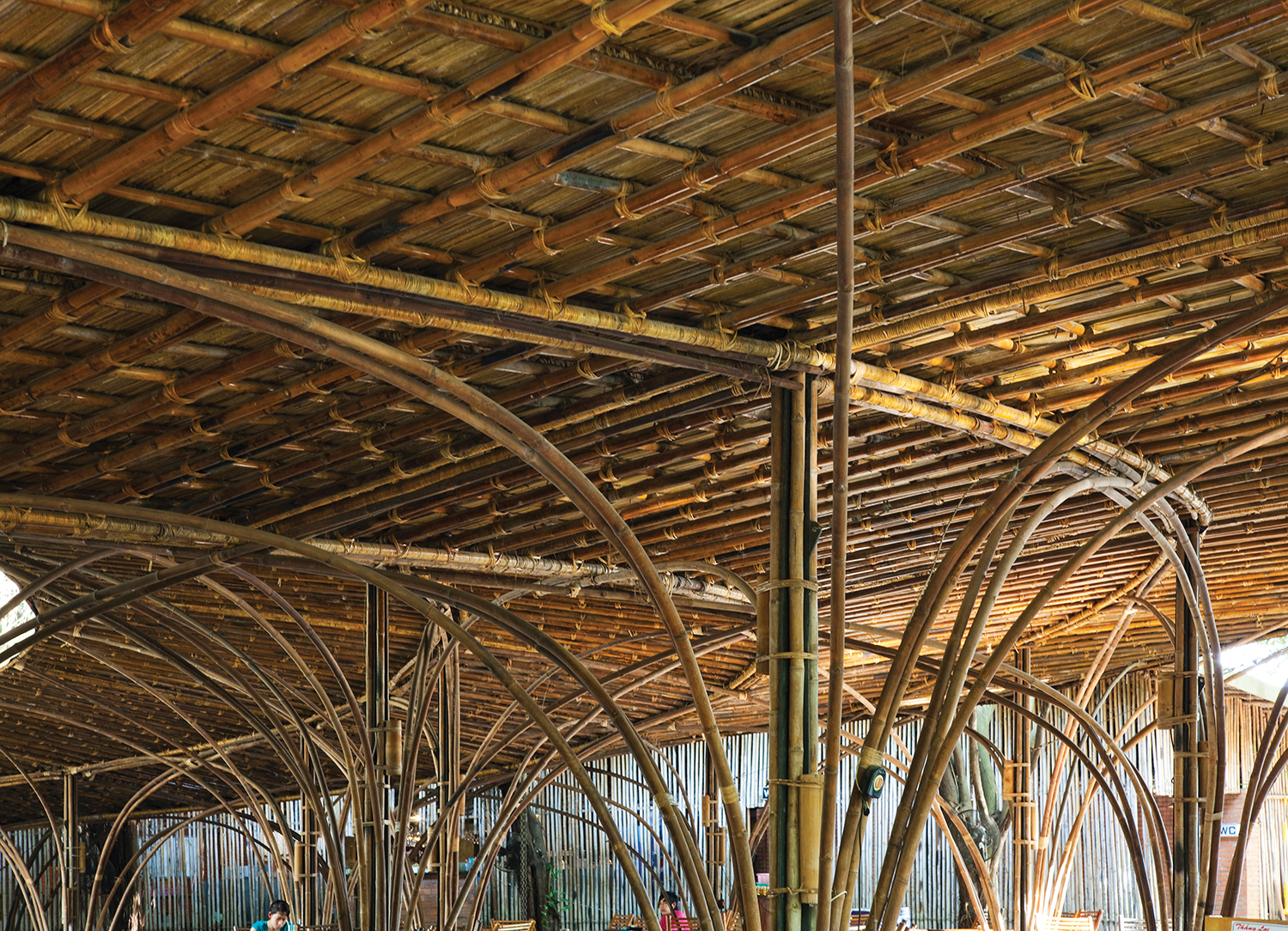 One of their earliest experiences with bamboo, WNW Cafe's spacious wide span is supported by a beautifully flexible bamboo structure that has been processed by traditional methods such as soaking in mud and smoking. Image © Vo Trong Nghia Architects